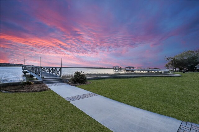 surrounding community featuring a water view and a lawn