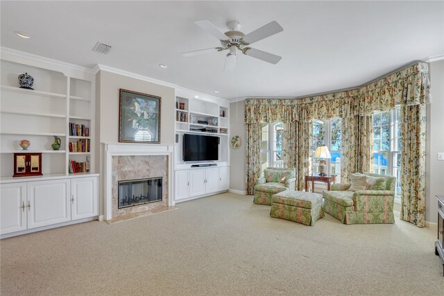 unfurnished living room with ceiling fan, light colored carpet, a premium fireplace, and crown molding