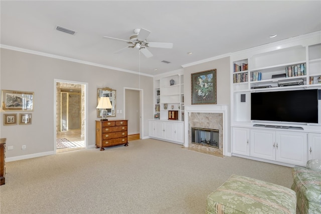 living room featuring light carpet, built in shelves, ceiling fan, and ornamental molding