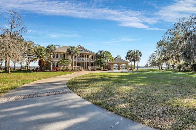 view of front of house with a balcony and a front lawn