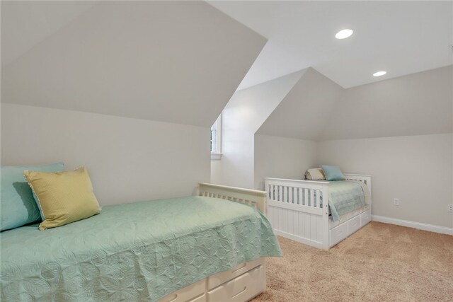 bedroom featuring light colored carpet and lofted ceiling