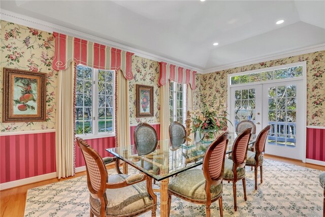 dining area with french doors, hardwood / wood-style floors, vaulted ceiling, and ornamental molding