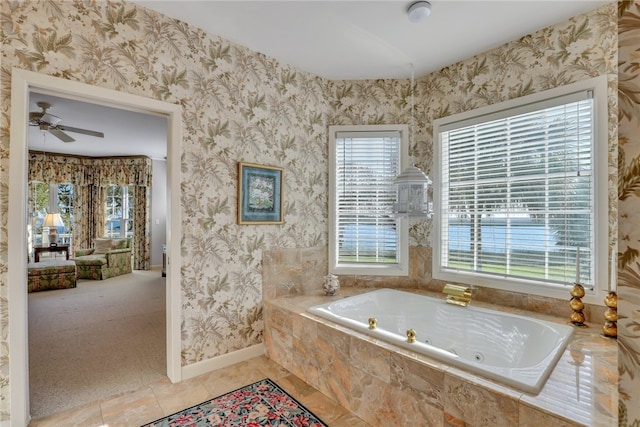 bathroom with tile patterned flooring, a relaxing tiled tub, and ceiling fan