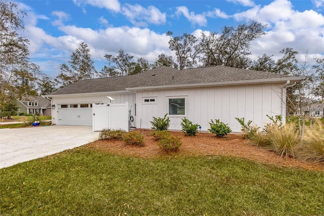 ranch-style house with a shingled roof, a front yard, driveway, and an attached garage