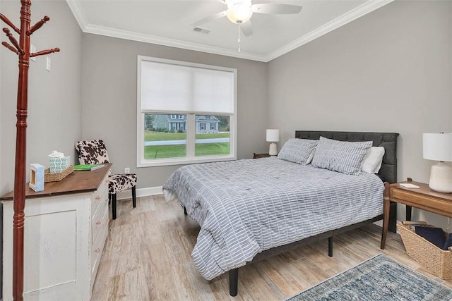 bedroom with light wood finished floors, baseboards, visible vents, a ceiling fan, and ornamental molding