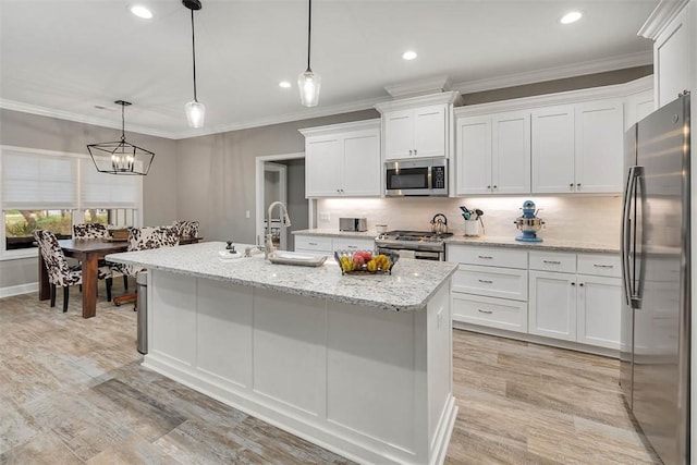 kitchen featuring appliances with stainless steel finishes, white cabinets, a sink, and ornamental molding