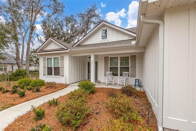 property entrance featuring a porch, a shingled roof, and board and batten siding