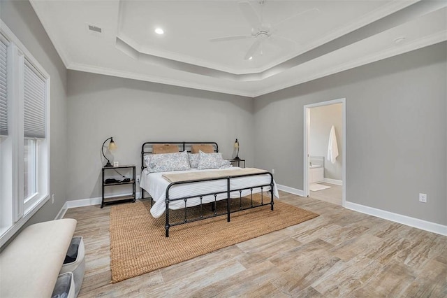 bedroom featuring a raised ceiling, crown molding, baseboards, and wood finished floors