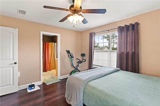 bedroom featuring ceiling fan, dark wood-type flooring, visible vents, baseboards, and ensuite bath