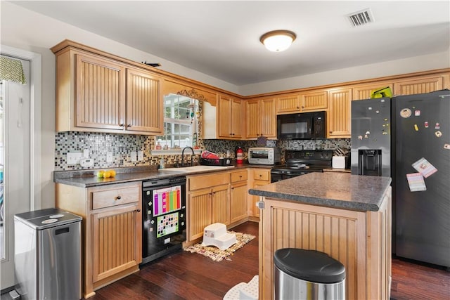 kitchen featuring black appliances, dark wood-style floors, visible vents, and a sink