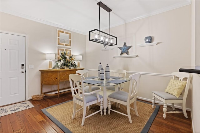 dining area with crown molding, dark hardwood / wood-style floors, and a notable chandelier