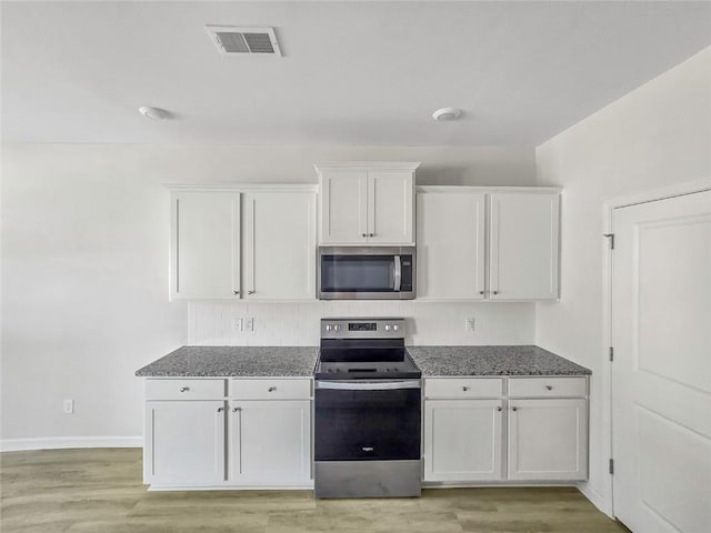 kitchen featuring white cabinets, visible vents, appliances with stainless steel finishes, and light wood-type flooring