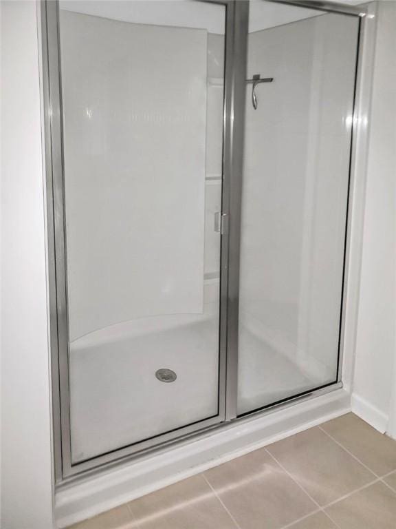 full bathroom with tile patterned flooring and a stall shower