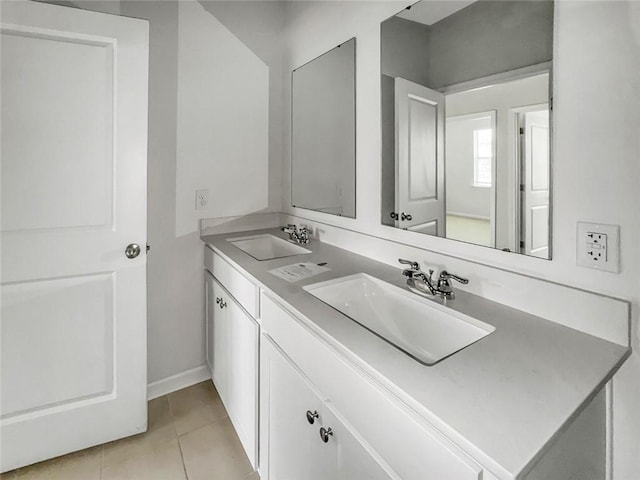 full bath with a sink, double vanity, and tile patterned flooring