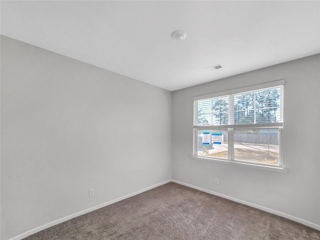 empty room featuring visible vents, baseboards, and carpet floors