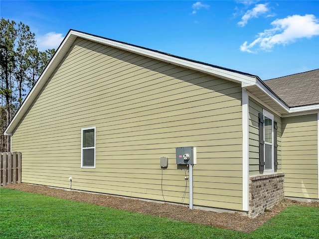 view of property exterior featuring a lawn and fence