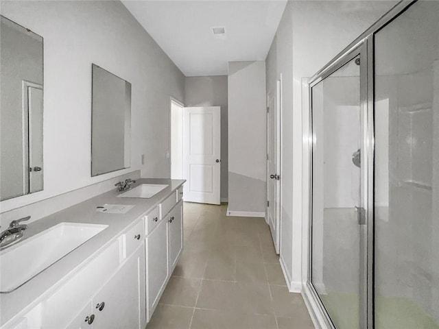 bathroom with tile patterned flooring, a stall shower, and a sink