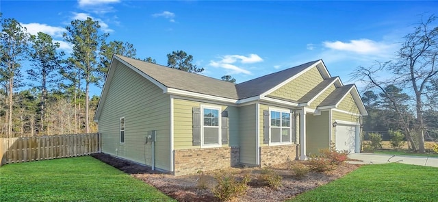 view of home's exterior with fence, driveway, an attached garage, a yard, and brick siding