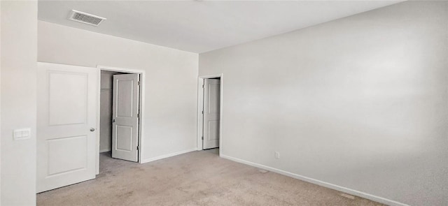 unfurnished bedroom featuring baseboards, visible vents, and light carpet