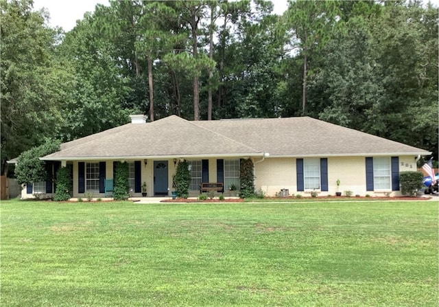 281 Cambridge Cir, Kingsland, GA 31548 - ranch-style home with covered porch, a front yard, a chimney, and view of wooded area
