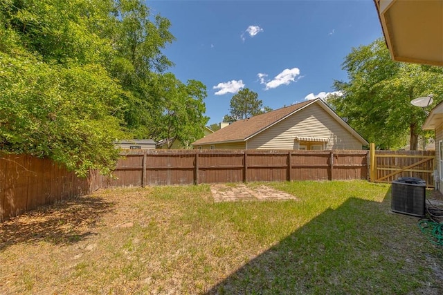 view of yard featuring a fenced backyard and central AC