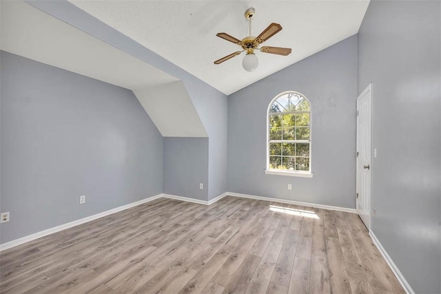 bonus room featuring vaulted ceiling, baseboards, a ceiling fan, and wood finished floors
