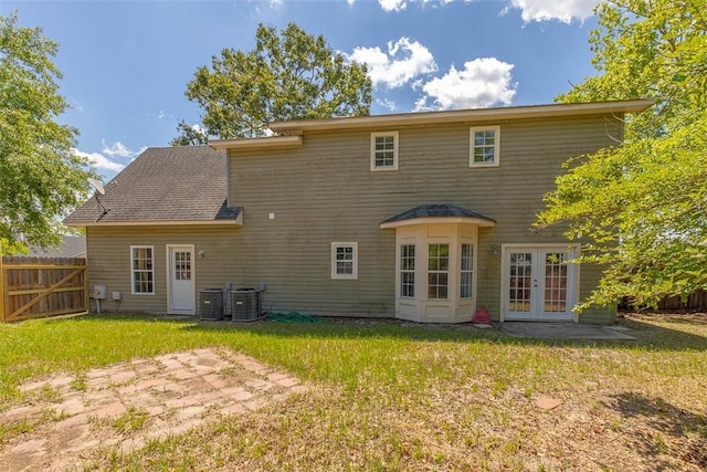 rear view of house featuring a patio, french doors, fence, central AC unit, and a yard