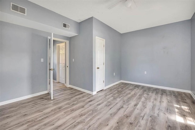 spare room with ceiling fan, baseboards, visible vents, and wood finished floors