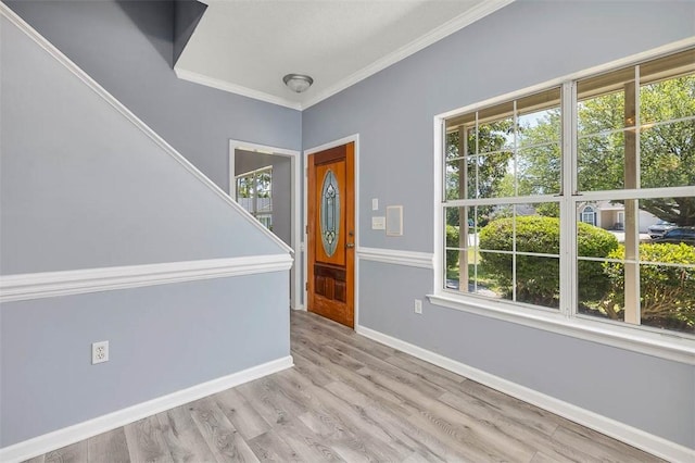 interior space with crown molding, baseboards, a healthy amount of sunlight, and wood finished floors