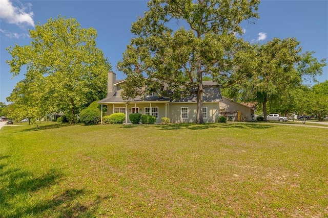 exterior space featuring a chimney and a front lawn