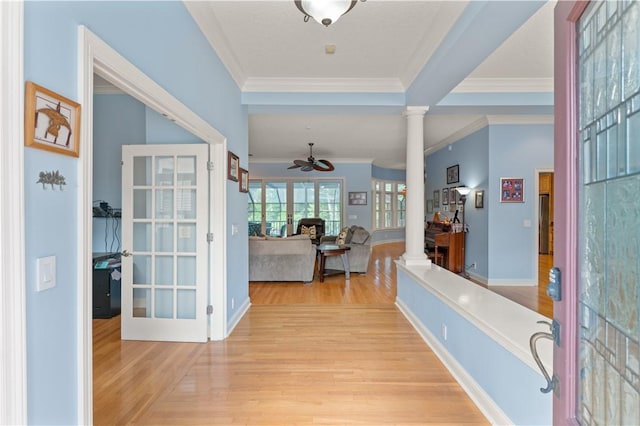 foyer with decorative columns, ceiling fan, wood finished floors, crown molding, and french doors