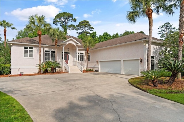 ranch-style home with a garage, stucco siding, and concrete driveway