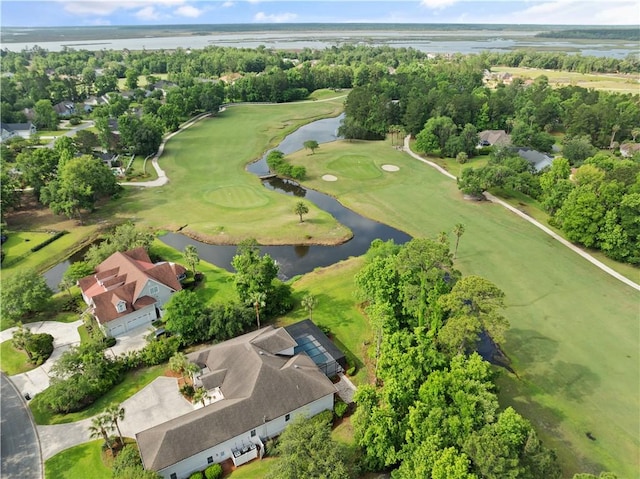 aerial overview of property's location with a local golf course, a nearby body of water, a tree filled landscape, and nearby suburban area