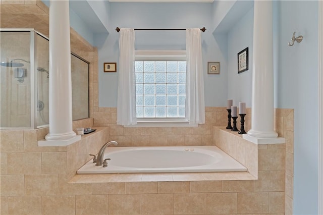 bathroom featuring decorative columns, a stall shower, and a garden tub