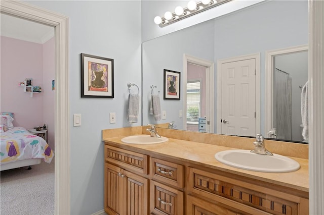 ensuite bathroom featuring double vanity and crown molding