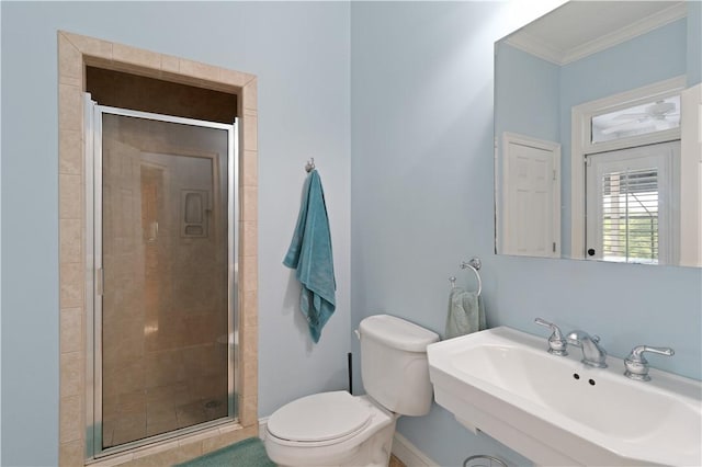bathroom with a sink, a shower stall, ornamental molding, toilet, and baseboards
