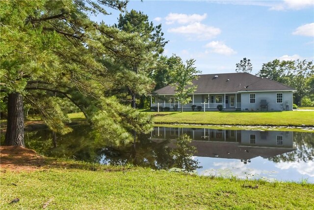 back of property featuring a yard and a water view