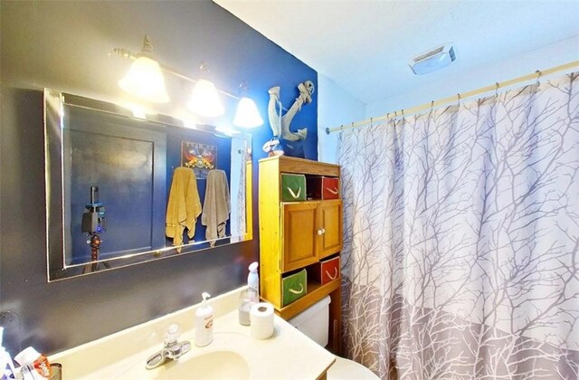 315 Magnolia St, Waycross, GA 31501 - bathroom with toilet, vanity, curtained shower, and visible vents