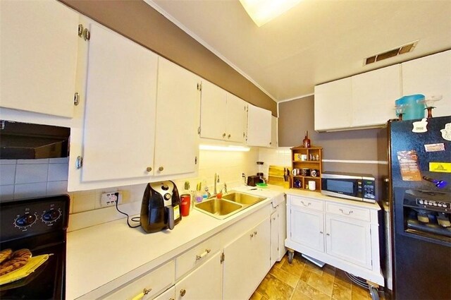 315 Magnolia St, Waycross, GA 31501 - kitchen featuring visible vents, stainless steel microwave, under cabinet range hood, a sink, and black refrigerator with ice dispenser