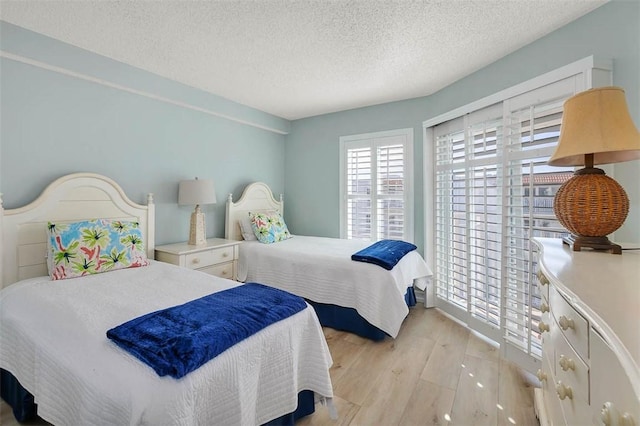 bedroom with a textured ceiling and light wood-type flooring