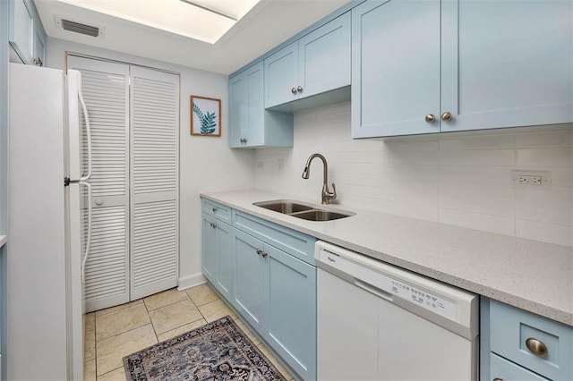 kitchen featuring tasteful backsplash, white appliances, sink, blue cabinetry, and light tile patterned floors