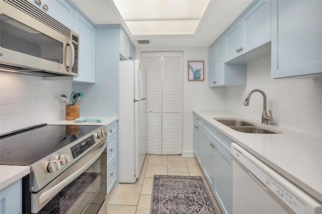 kitchen featuring decorative backsplash, sink, light tile patterned flooring, and stainless steel appliances