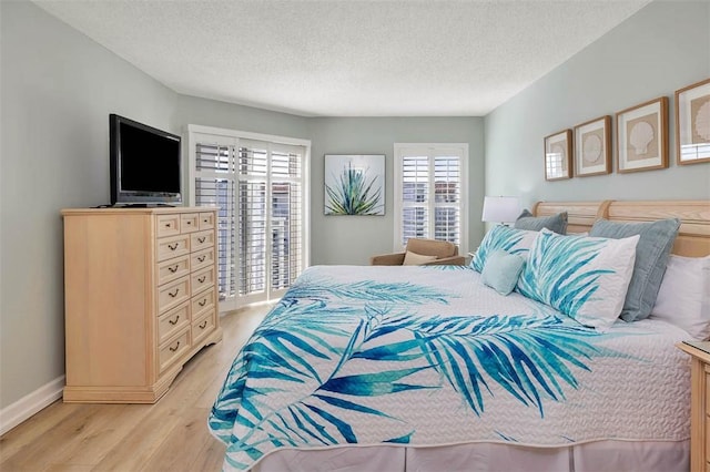 bedroom featuring light hardwood / wood-style floors and a textured ceiling