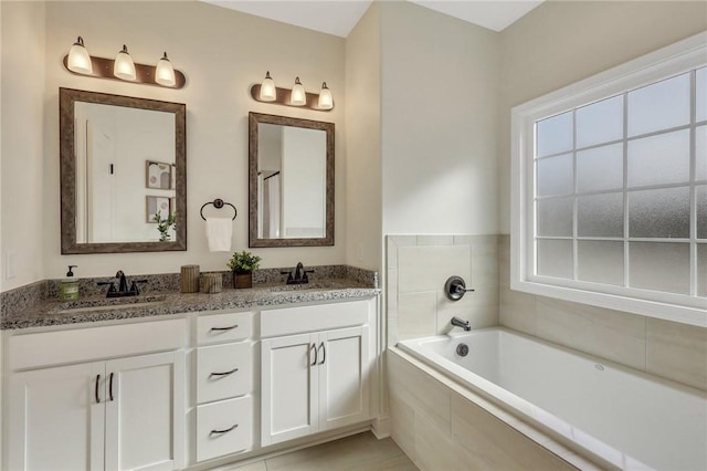 bathroom with vanity, tiled bath, and tile patterned floors