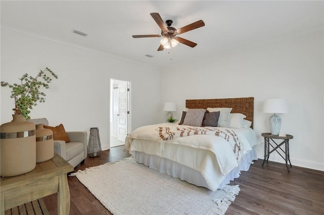 bedroom with ornamental molding, dark hardwood / wood-style floors, and ceiling fan