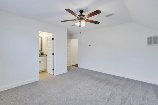 unfurnished bedroom featuring ceiling fan, ensuite bathroom, light colored carpet, and lofted ceiling