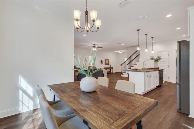 dining room with sink, ceiling fan with notable chandelier, and dark hardwood / wood-style floors