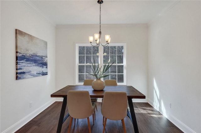 dining area featuring crown molding, dark wood-type flooring, and a chandelier