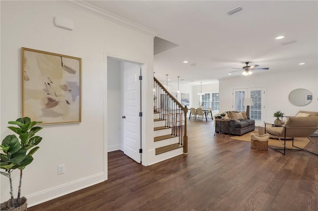 interior space with hardwood / wood-style floors, crown molding, and ceiling fan with notable chandelier