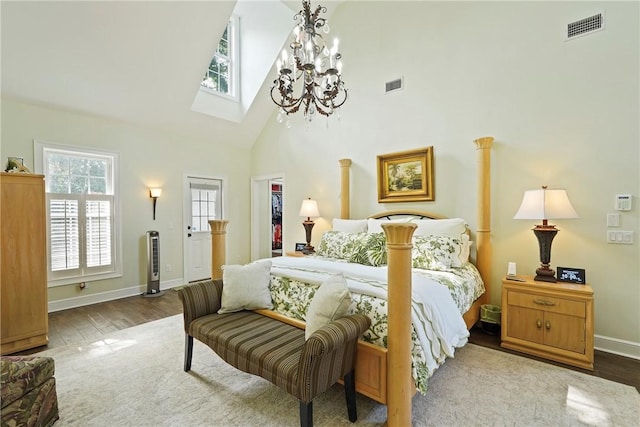 219 Abbott Ln, Saint Simons Island, GA 31522 - bedroom featuring a skylight, wood finished floors, high vaulted ceiling, a walk in closet, and a chandelier